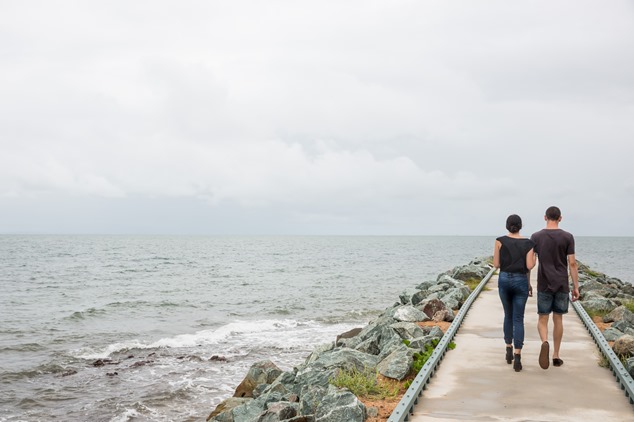 Two people walking away on seaside boardwalk
